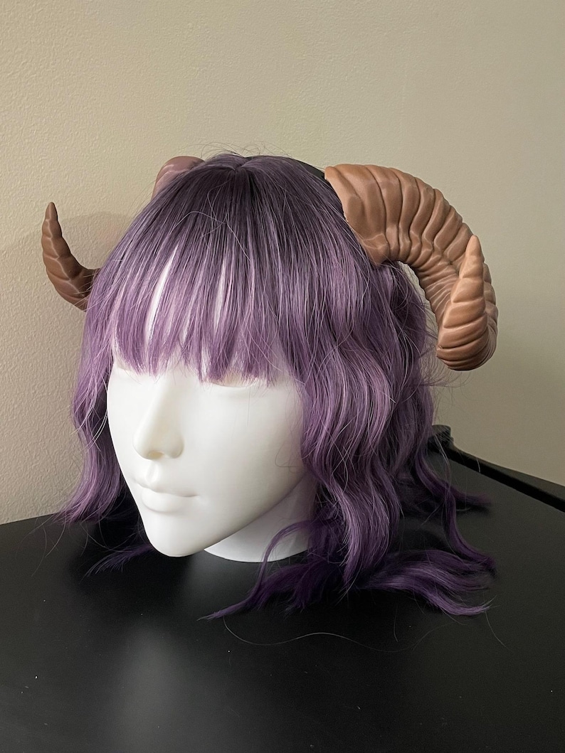 3D printed dark brown Nordic Ram Horns mounted to a black headband displayed on a mannequin