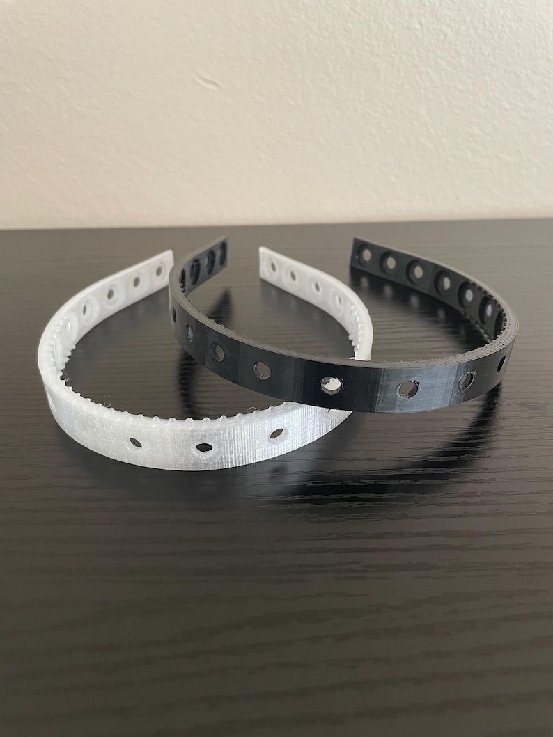 A semi clear and black headband featuring multiple screw holes for mounting horns and ears