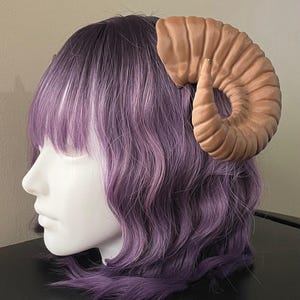 3D printed dark brown Nordic Ram Horns mounted to a black headband displayed on a mannequin
