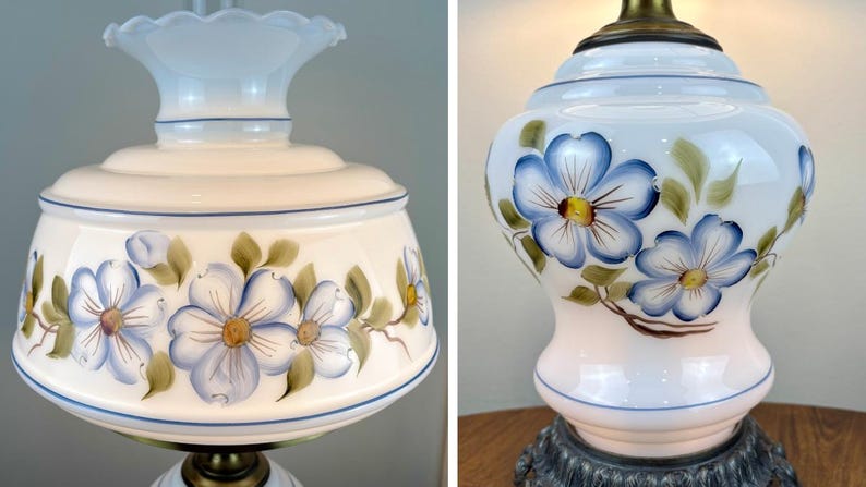May include: A white glass lamp with a blue and yellow floral design. The lamp has a white shade with a scalloped edge and a brass base.