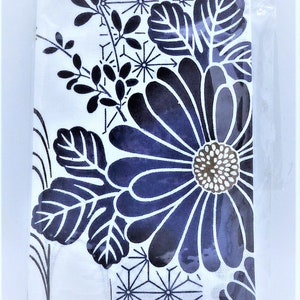 Puede incluir: Una tela con estampado floral blanco y azul marino, empaquetada en pl&aacute;stico transparente. El dise&ntilde;o presenta una gran flor estilizada con p&eacute;talos azul oscuro y un centro marr&oacute;n, rodeada de hojas y patrones geom&eacute;tricos.