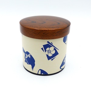Könnte beinhalten: Eine zylindrische Holzkiste mit einem braunen Deckel und einem weißen Korpus. Die Kiste ist mit einem blau-weißen Muster aus Blumen und Essstäbchen verziert.