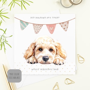 May include: A birthday card with a watercolour illustration of a golden dog. The card reads "Did someone say cake?" above the dog and "Happy Birthday Dad" below. Pastel-coloured bunting decorates the top.