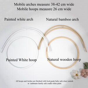 May include: A set of mobile components including a painted white arch and hoop, and a natural bamboo arch and wooden hoop. Text states mobile arches measure 38-42 cm wide and mobile hoops measure 26 cm wide, with a food grade baby safe finish.