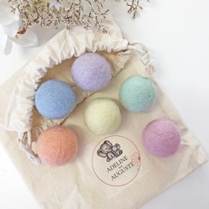 May include: Six pastel-coloured felt balls in a white drawstring bag. The bag has a label with the text "Adeline and Auguste".