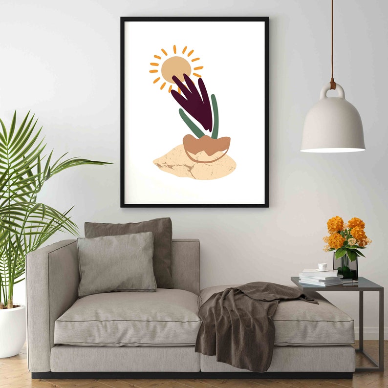 May include: Abstract art print featuring a stylized sun, a purple flower, and a green plant on a beige background. The print is framed in black.