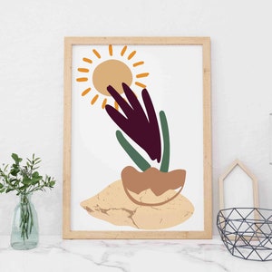 May include: A framed print with an abstract design featuring a stylized sun, a purple flower, and green leaves. The background is a light beige color.