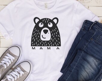 May include: White t-shirt with a black and white illustration of a bear's face and the word "MAMA" underneath.