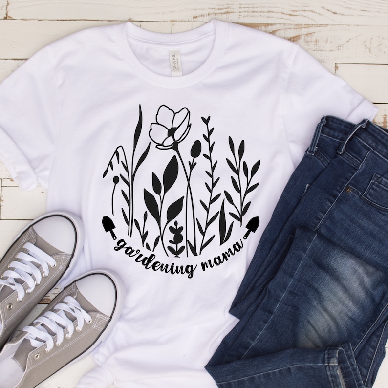 May include: White t-shirt with a black graphic of flowers and the text "gardening mama".