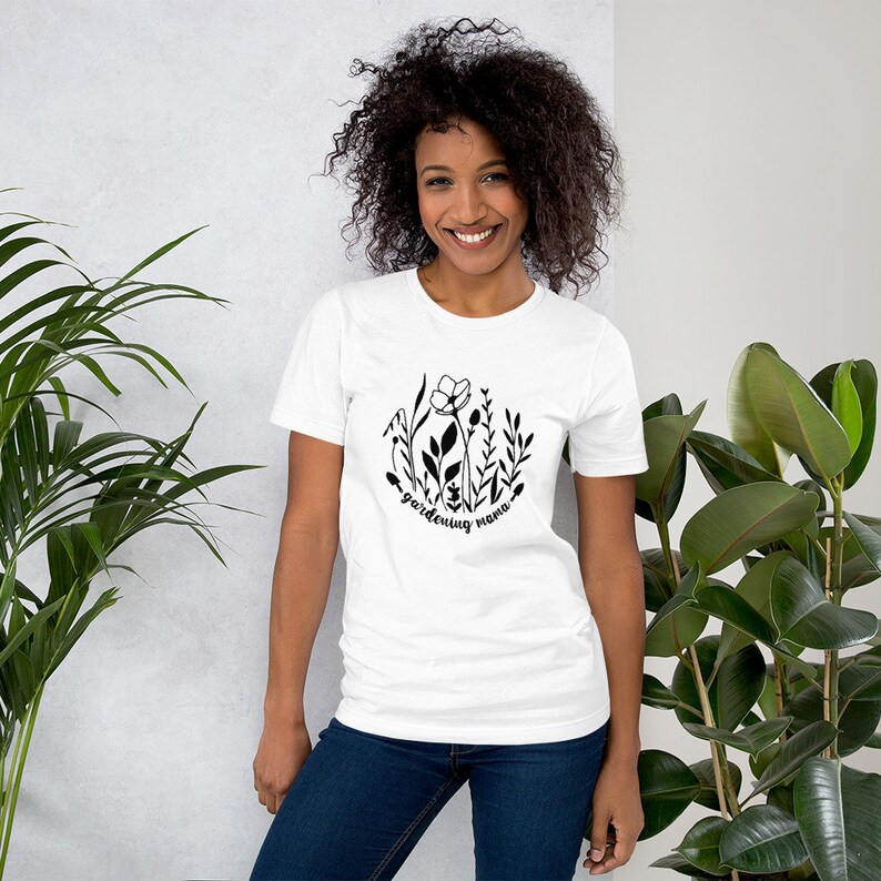 May include: White t-shirt with a black graphic of stylised flowers and the text "gardening mama".