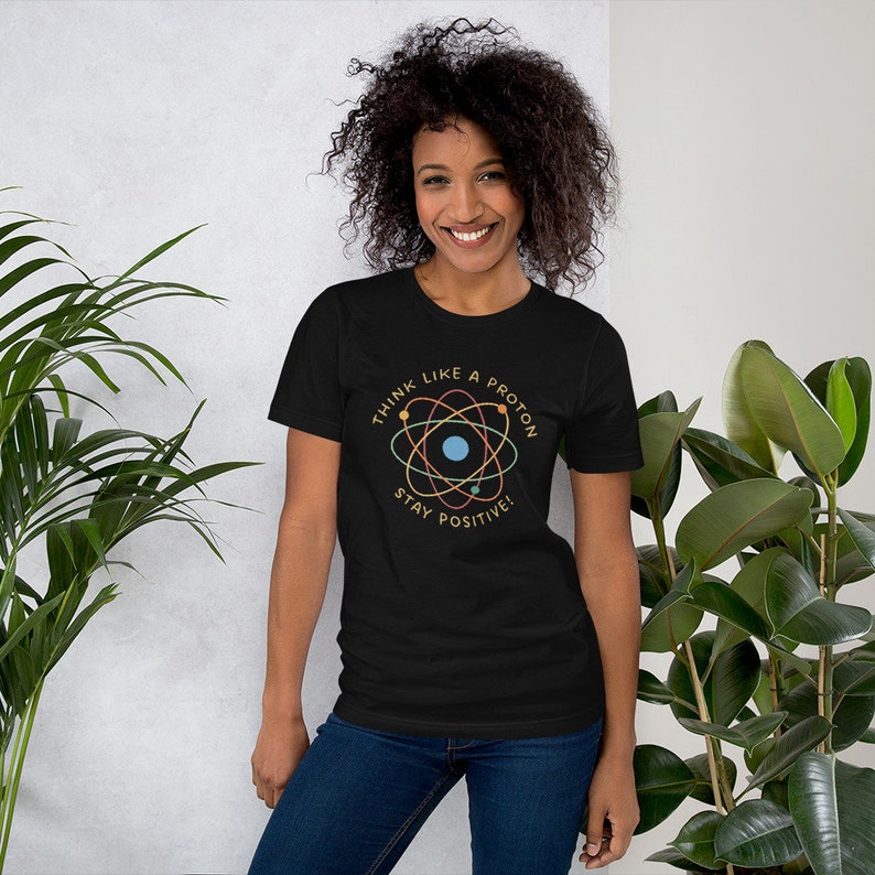 May include: Black t-shirt with a colorful atom graphic and the text "Think like a proton. Stay positive."