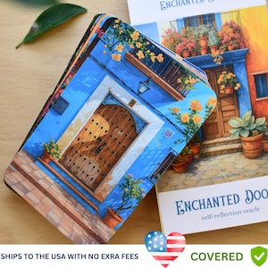 May include: A deck of "Enchanted Doors" self-reflection oracle cards. The cards feature a blue door with a wooden door and a colourful building. The card deck is next to a book with the same image. The text "Enchanted Doors" is visible.