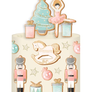 May include: A white cake decorated with gingerbread cookies. The cookies are decorated with pink, blue and green icing and glitter. The cookies include a Christmas tree, a ballerina, a rocking horse, a nutcracker, a drum and a gift box.