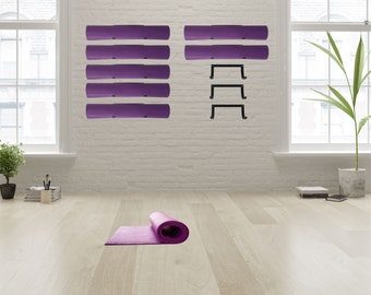 May include: A purple yoga mat rolled up on a light wood floor. A white brick wall with four purple yoga mats hanging on hooks and three black metal hooks.