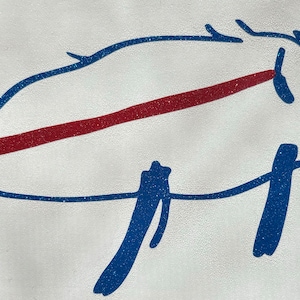 May include: A blue glitter pig with a red glitter line across its body. The pig has a simple, childlike drawing style.