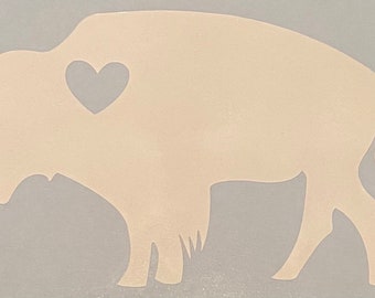 May include: A beige silhouette of a bison with a small white heart in the center of its chest.