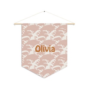May include: A pink and white fabric banner with a wave pattern and the name "Olivia" in orange text.