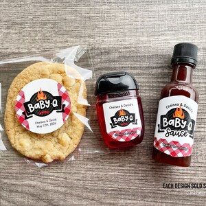 Personalized Baby-Q baby shower favors with gingham labels, including mini bottles for barbecue sauce, liquor, or hand sanitizer, plus round favor labels for treat bags at a BBQ themed shower.