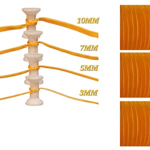May include: Four spools of yellow velvet ribbon in different widths: 3mm, 5mm, 7mm, and 10mm. The ribbon is wound around wooden spools.