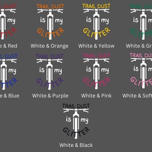 Puede incluir: Una silueta blanca de una bicicleta de monta&ntilde;a con el texto "TRAIL DUST is my GLITTER" en varios colores. Los colores incluyen rojo, naranja, amarillo, verde, azul, morado, rosa, rosa suave y negro.
