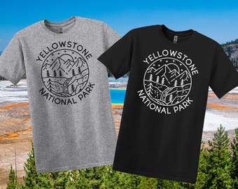 May include: Two short-sleeved t-shirts, one grey and one black, each displaying a circular graphic. The graphic includes mountains, trees, a waterfall, and the text "Yellowstone National Park" in a circular design.