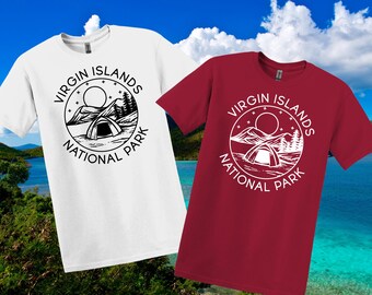 May include: Two t-shirts, one white and one red, each with a circular graphic that reads "Virgin Islands National Park." The graphic shows a tent, mountains, a sun, and trees. The shirts have short sleeves.