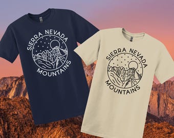 May include: Two t-shirts featuring a graphic design of a mountain range with a moon and stars. The text "Sierra Nevada Mountains" is printed in a circle around the graphic. One t-shirt is navy blue and the other is beige.
