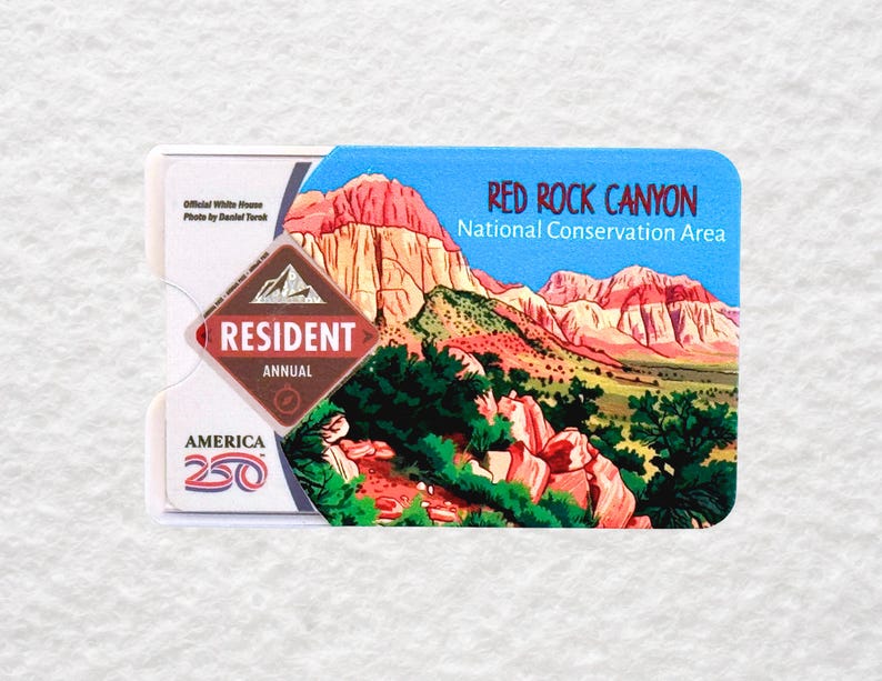 May include: A Resident Annual pass for Red Rock Canyon National Conservation Area. The pass features a scenic illustration of the canyon with red rock formations and green vegetation. The pass also includes the text "America 250".