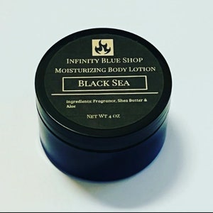 May include: A round black container of Infinity Blue Shop Moisturizing Body Lotion in the scent Black Sea. The label features a flame icon, lists ingredients as fragrance, shea butter, and aloe, and states a net weight of 4 oz on the lid.