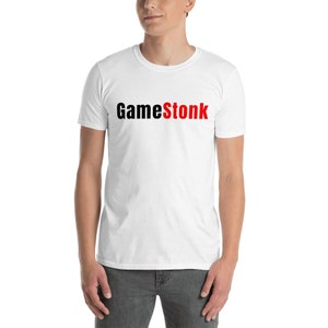 Könnte beinhalten: Weißes T-Shirt mit dem Aufdruck "GameStonk" in schwarzen und roten Buchstaben.