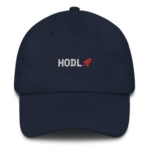May include: A navy blue baseball cap with a white embroidered rocket and the text "HODL" in white.