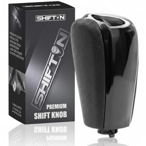 May include: A black and chrome premium shift knob with a textured leather grip. The product is packaged in a black box with the brand name "SHIFTIN" in silver lettering. The box also lists features like "ergonomic design" and "luxury replacement."