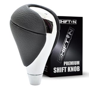 May include: A gear shift knob featuring a textured black leather-like upper section and a smooth white base. The product is displayed next to a black box with the text SHIFTON and PREMIUM SHIFT KNOB printed in white, featuring a gear icon logo.