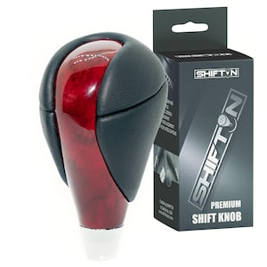 May include: A premium shift knob with a glossy, dark red wood grain finish, accented by black leather and a white base. The product is packaged in a black box with the "SHIFT ON" logo and product information.