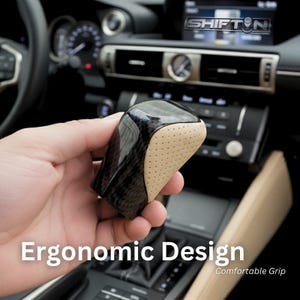 May include: A black and tan car shift knob with an ergonomic design. The shift knob has a carbon fiber appearance with a tan, perforated leather grip. The text "Ergonomic Design" and "Comfortable Grip" are visible.