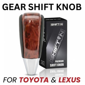 May include: A gear shift knob with a polished wood grain center, black side panels, and a silver base. It is displayed next to a black box labeled SHIFTN PREMIUM SHIFT KNOB. The text GEAR SHIFT KNOB FOR TOYOTA & LEXUS appears in the image.