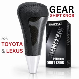 May include: A black gear shift knob with a textured leather-like top, a carbon fiber pattern center insert, and a smooth silver metallic base. The product is displayed next to its black packaging box labeled SHIFTON PREMIUM SHIFT KNOB.