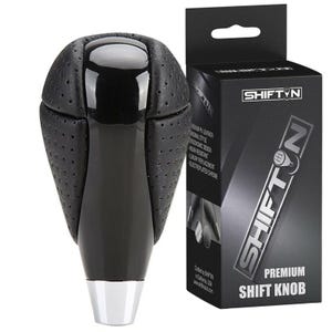 May include: A black and silver premium shift knob with a perforated leather top and a glossy black shaft. The product is displayed next to its black box, which features the brand name "SHIFTYN" in silver.