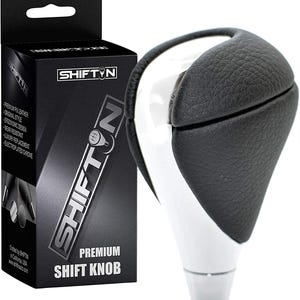 May include: A premium shift knob with a black leather grip and a white, chrome-plated body. The product is packaged in a black box with the "SHIFTIN" logo and product details. The shift knob is designed for a comfortable grip.