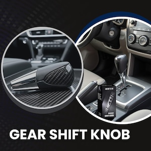 May include: A black and silver gear shift knob with a carbon fiber design. The image also shows a box with the text "SHIFT-N PREMIUM SHIFT KNOB" and the words "GEAR SHIFT KNOB" at the bottom.