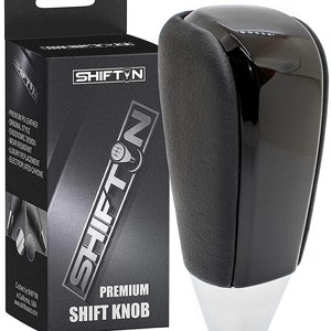 May include: Black leather shift knob with a chrome base. The knob is designed to be ergonomic and comfortable to grip. It is a replacement for a standard shift knob and is compatible with most vehicles.