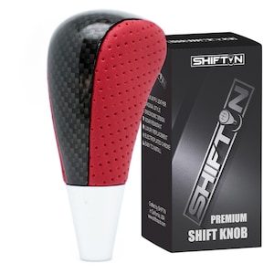May include: A premium shift knob with a carbon fiber and red perforated leather design. The shift knob has a white base and is packaged in a black box with the "SHIFTIN" logo and the words "PREMIUM SHIFT KNOB".
