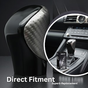 May include: A black and silver shift knob with a carbon fiber pattern. The image shows the shift knob installed in a car, with the text "Direct Fitment" and "Superb Replacement".