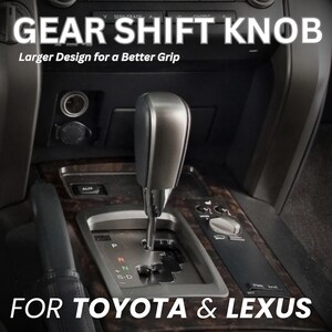 May include: A silver and black gear shift knob installed in a vehicle center console. The text GEAR SHIFT KNOB Larger Design for a Better Grip and FOR TOYOTA & LEXUS is overlaid on the image. The shifter features a metallic finish.