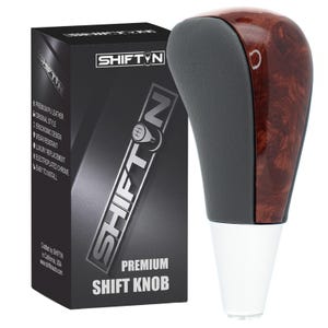May include: A premium shift knob with a dark wood grain finish and a gray top. The knob is paired with a black box that has the text "SHIFTIN" and "PREMIUM SHIFT KNOB". The box also lists features like "premium PU leather" and "ergonomic design".