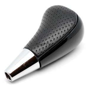 May include: Black and chrome car gear shift knob. The top is black leather with small perforations. The bottom is glossy black plastic, and the base is chrome. The shift knob is designed for a car.