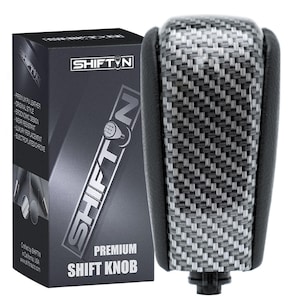 May include: A premium shift knob with a carbon fiber weave pattern and black leather accents. The product is packaged in a dark gray box with the text "SHIFTIN" and "PREMIUM SHIFT KNOB".