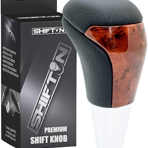 May include: A premium shift knob with a black leather top and wood grain accents. The knob has a white base and is packaged in a black box with the "SHIFTIN" logo and product details.