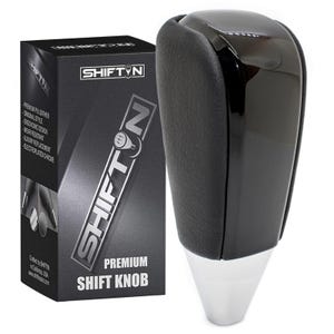 May include: A black and silver shift knob with a glossy top and a textured leather grip. The product is displayed next to its black box, which features the brand name "SHIFTIN" and product details. The box also states "PREMIUM SHIFT KNOB".