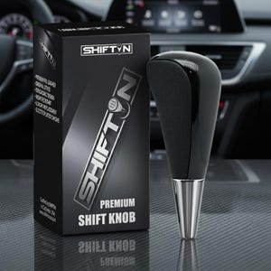 May include: A black premium shift knob with a silver base and a black box with the text "SHIFT N" and "PREMIUM SHIFT KNOB". The box also lists features like "premium pu leather" and "ergonomic design".